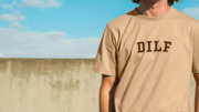 A person wearing a tan funny Dad T-shirt with