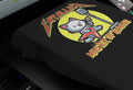 black t-shirt with a graphic of a cat playing a guitar and the slogan catallica master of humans