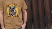 A person wears a funny animal T-shirt with a playful design of a koala in sunglasses holding a pineapple and a drink. Text reads