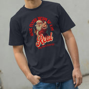 Man wearing a black T-shirt with a playful Santa design, featuring the text