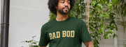 Man with curly hair and beard wears a Fathers Day gift, a dark green