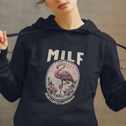 Young woman wearing a navy graphic hoodie featuring a pink flamingo illustration and the text
