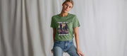 Young woman in a casual pose wears a green music T-shirt with a graphic of police officers and the phrase 