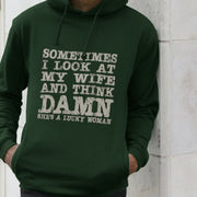 Man in a dark green Slogan hoodie with humorous white text saying, 