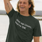 A man with curly hair smiles while wearing a dark green beer T-shirt with the text 