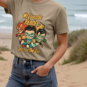 Woman wearing a beige Festival t-shirt with cartoon superheroes and the text 