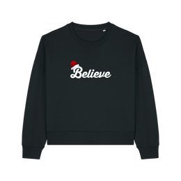black christmas sweater with the slogan 'believe' and a santa hat on top of the b