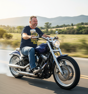 Man riding a motorcycle on a road with mountains in the background